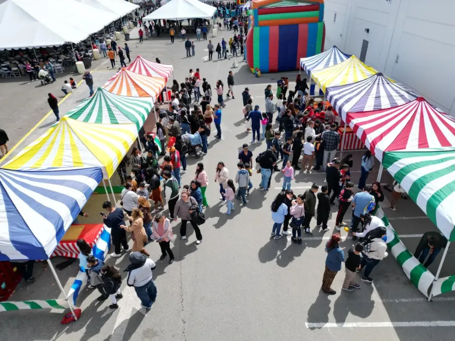 Rows of striped carnival game booths lined up on a field at a school carnival fundraiser